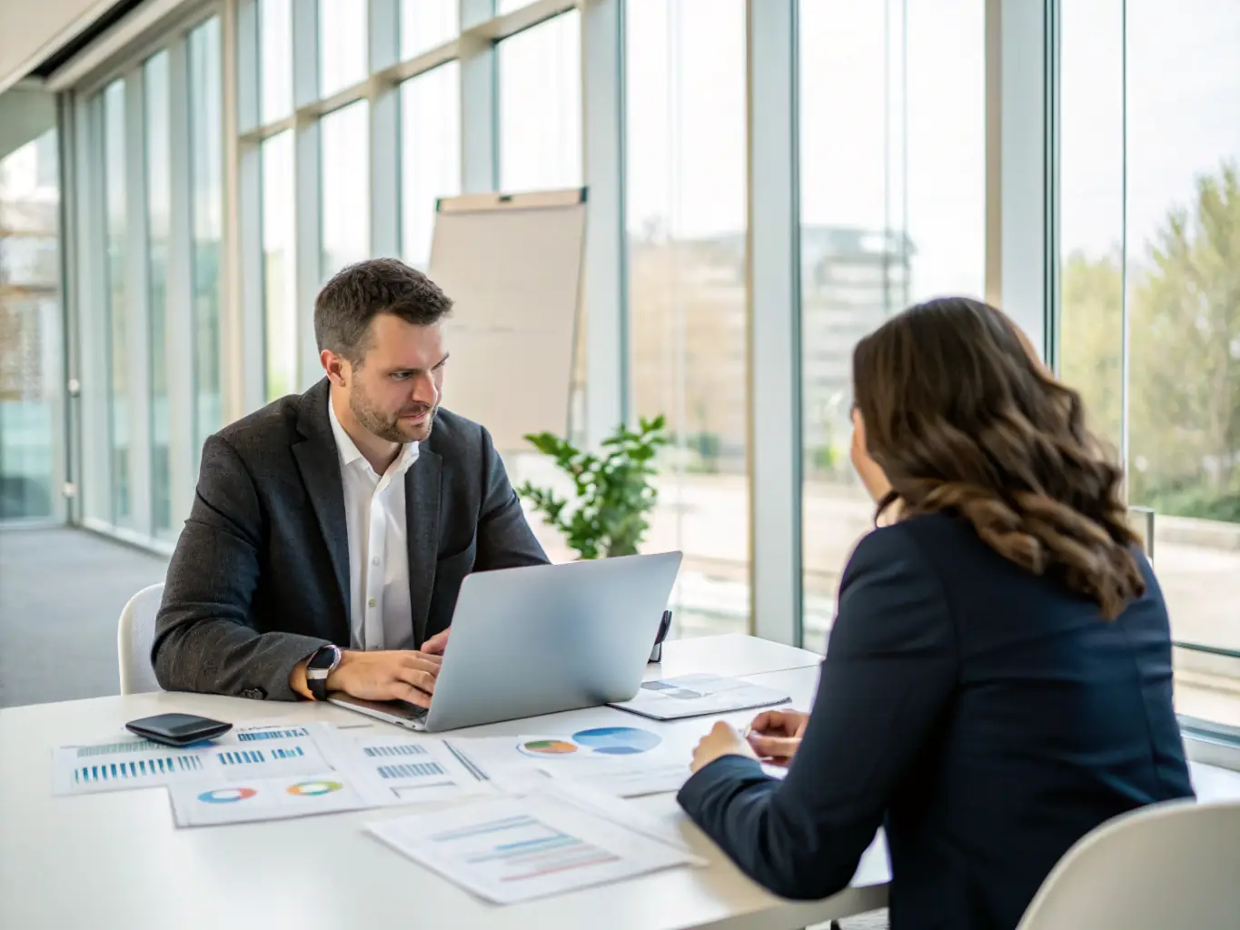 A professional image of a wheelspot.uno business coach reviewing strategic plans with a South African entrepreneur on a tablet in a modern office setting, discussing market dynamics and growth opportunities.